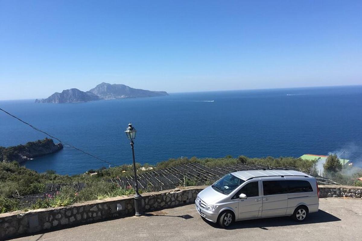 a silver van parked on a road next to the ocean