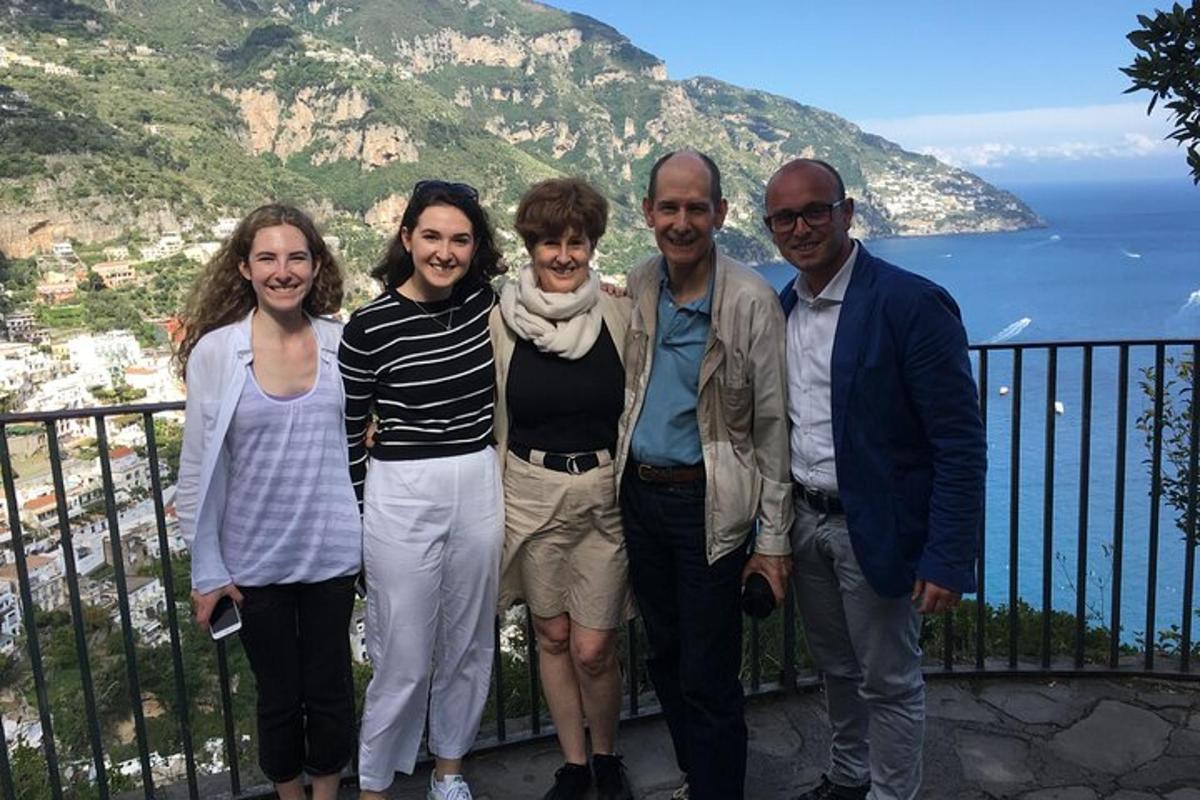 a group of people standing on a balcony overlooking the ocean