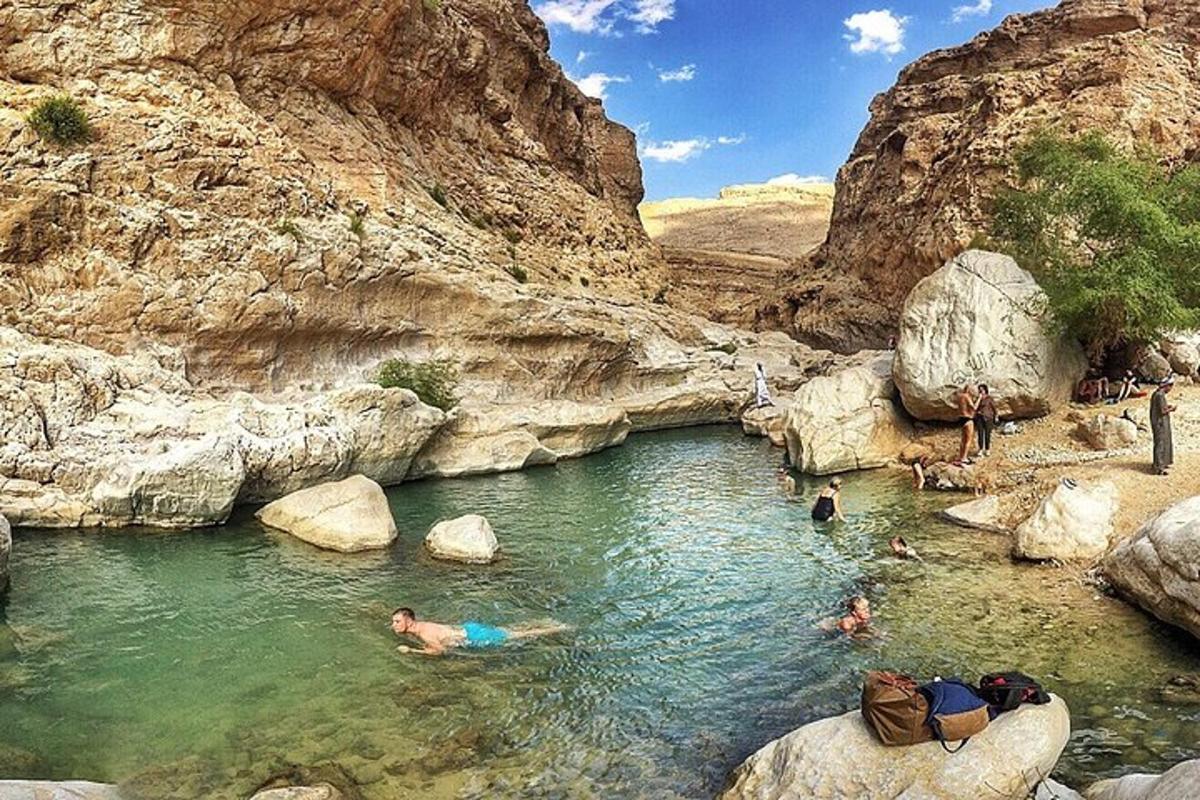 a group of people in a pool of water in a canyon
