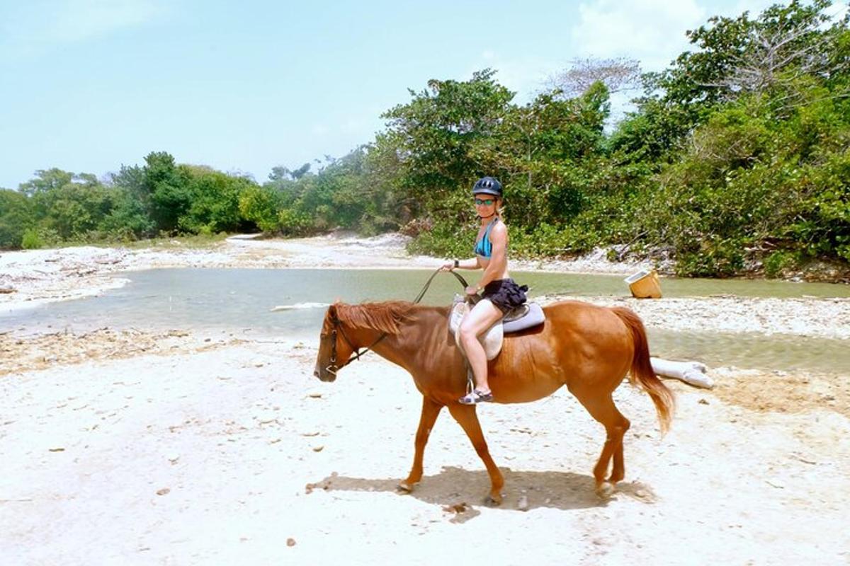 uma jovem cavalgando na praia