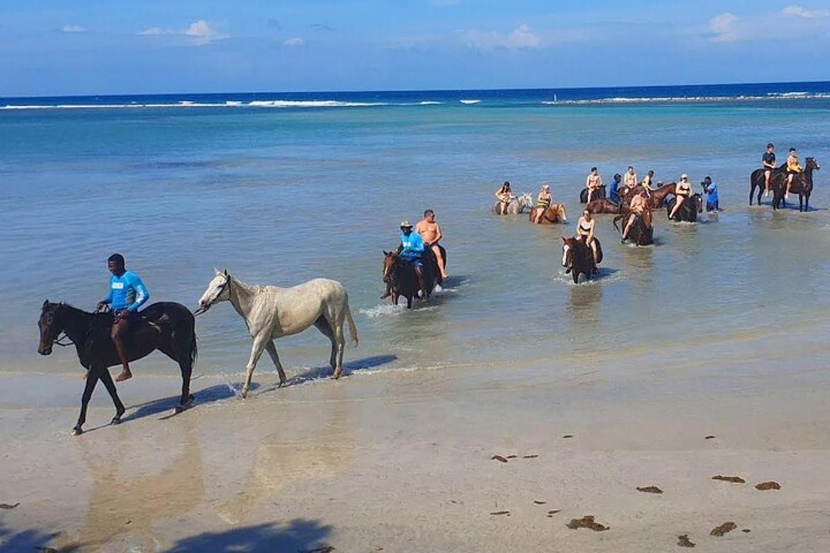 um grupo de pessoas andando a cavalo na praia