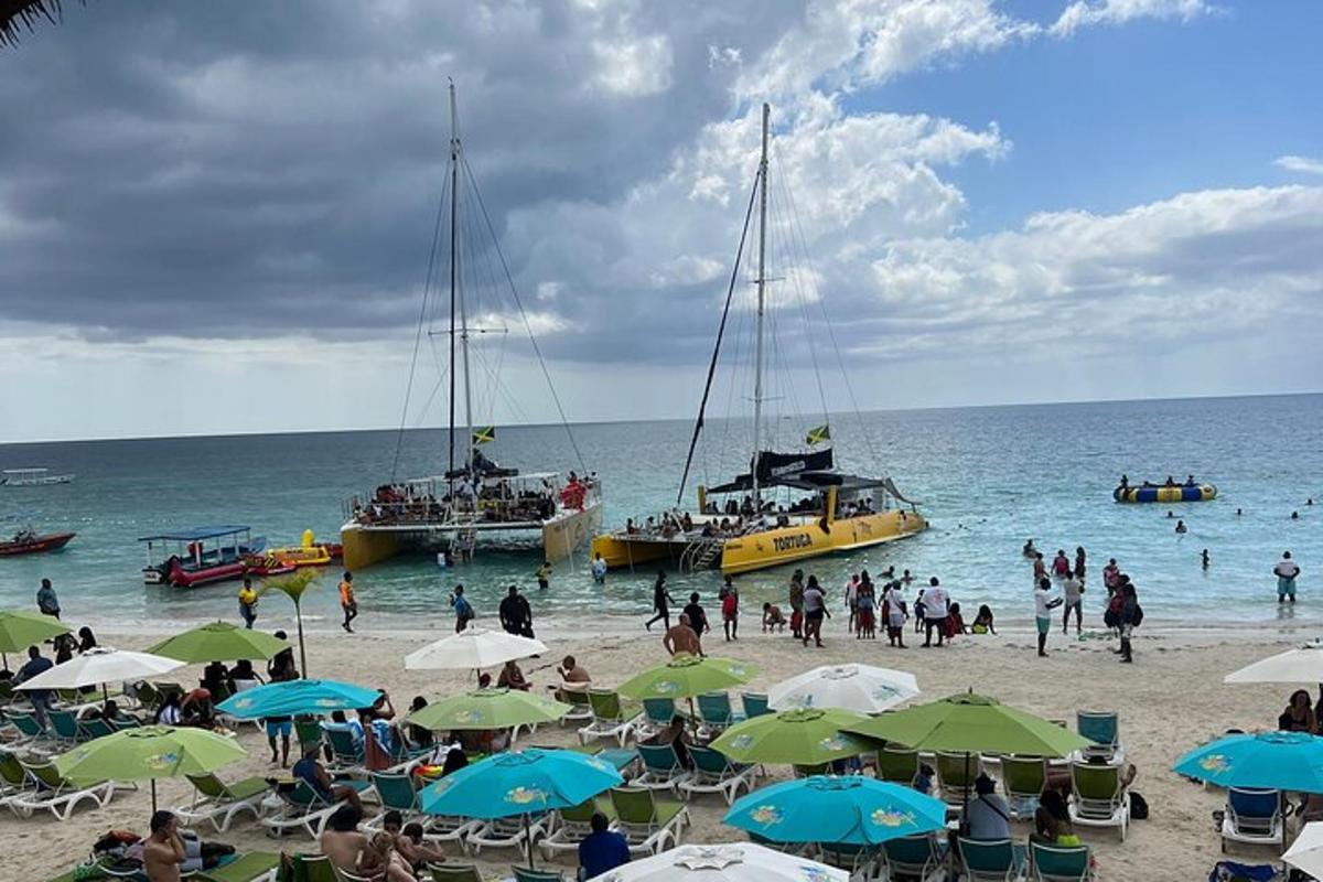 un groupe de personnes sur une plage avec des bateaux dans l'eau