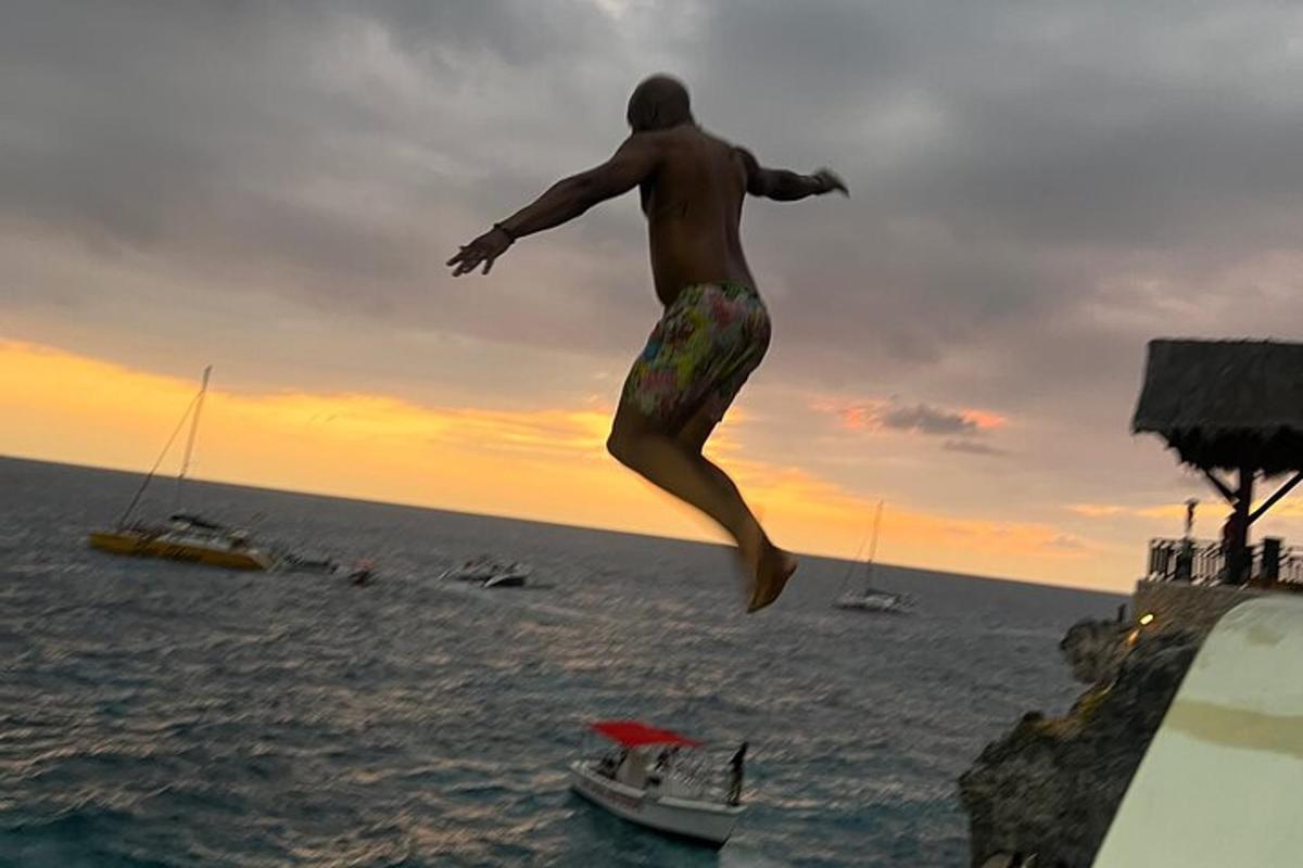 un uomo che salta da una scogliera in acqua