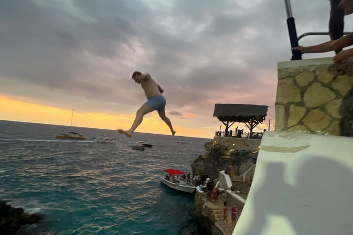 un uomo che salta da una scogliera in acqua
