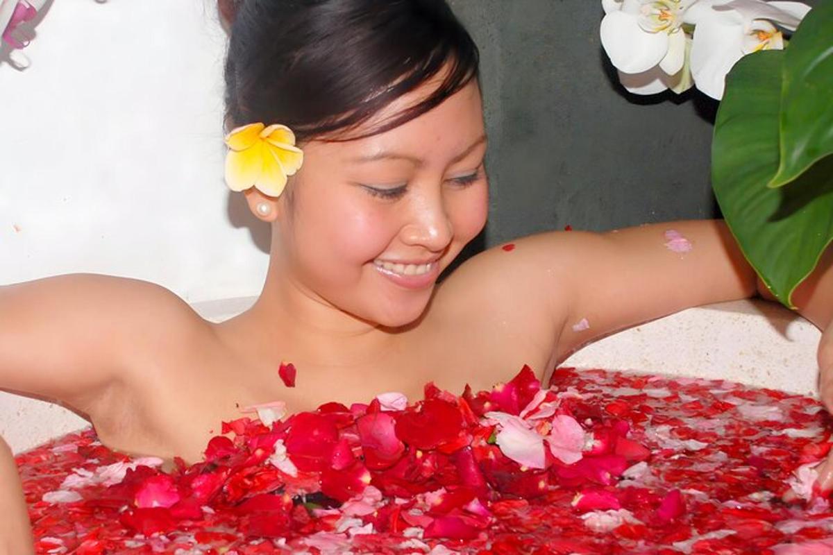 a woman laying on a pile of red flowers