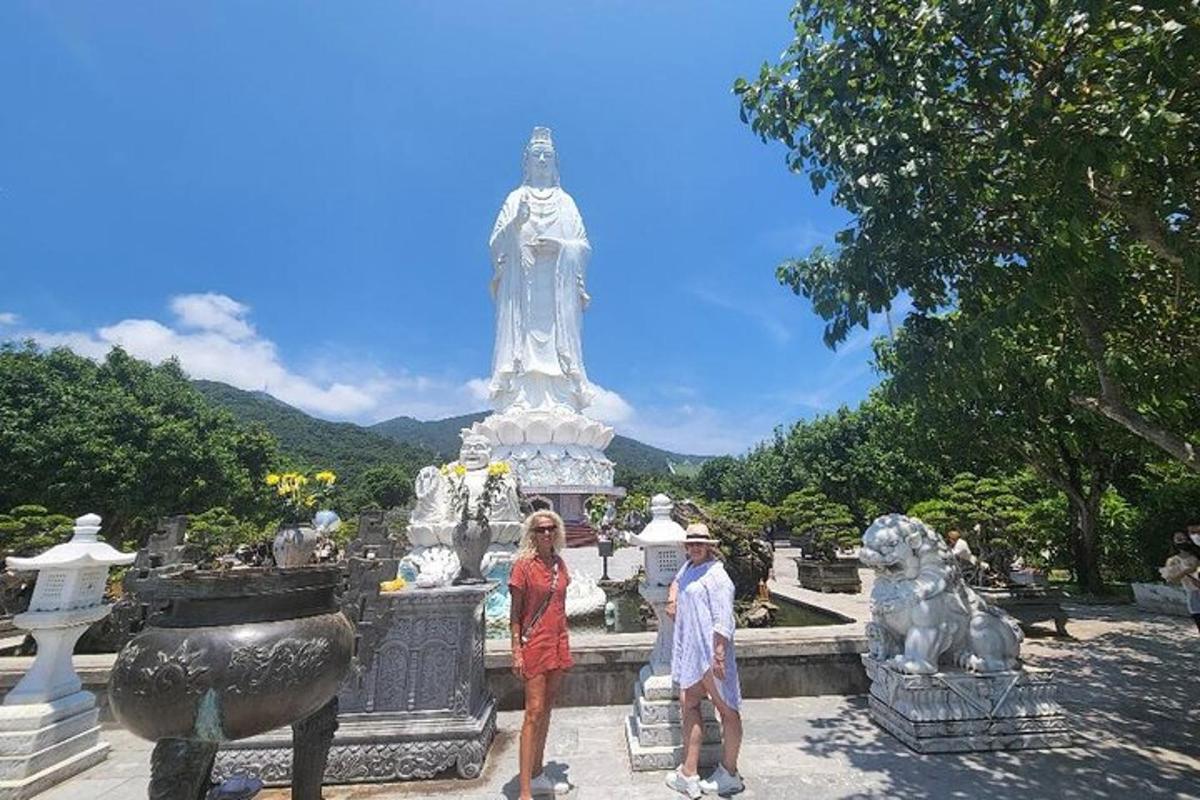 un uomo e una donna in piedi davanti a una statua