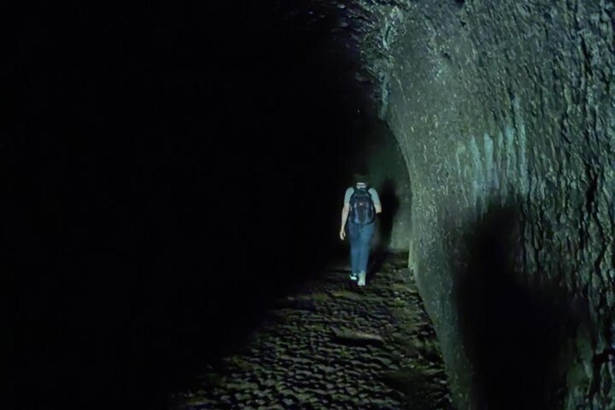 un hombre caminando por un túnel oscuro