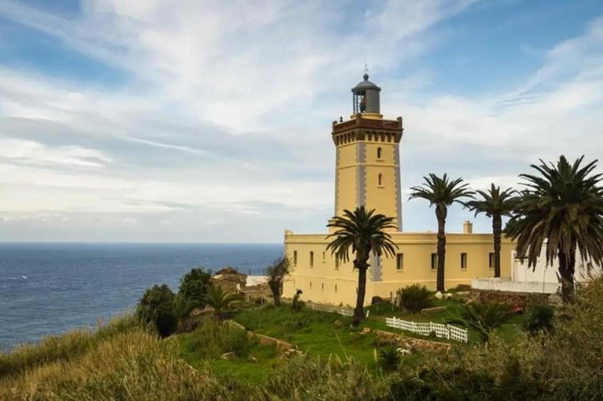 un faro en una colina junto al océano