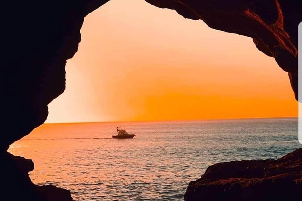 un bateau dans l'océan avec le coucher de soleil en arrière-plan