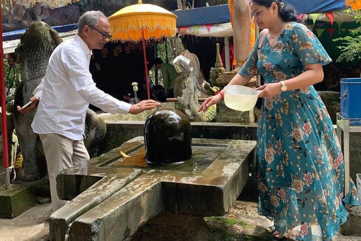 a man and a woman standing in front of a fountain