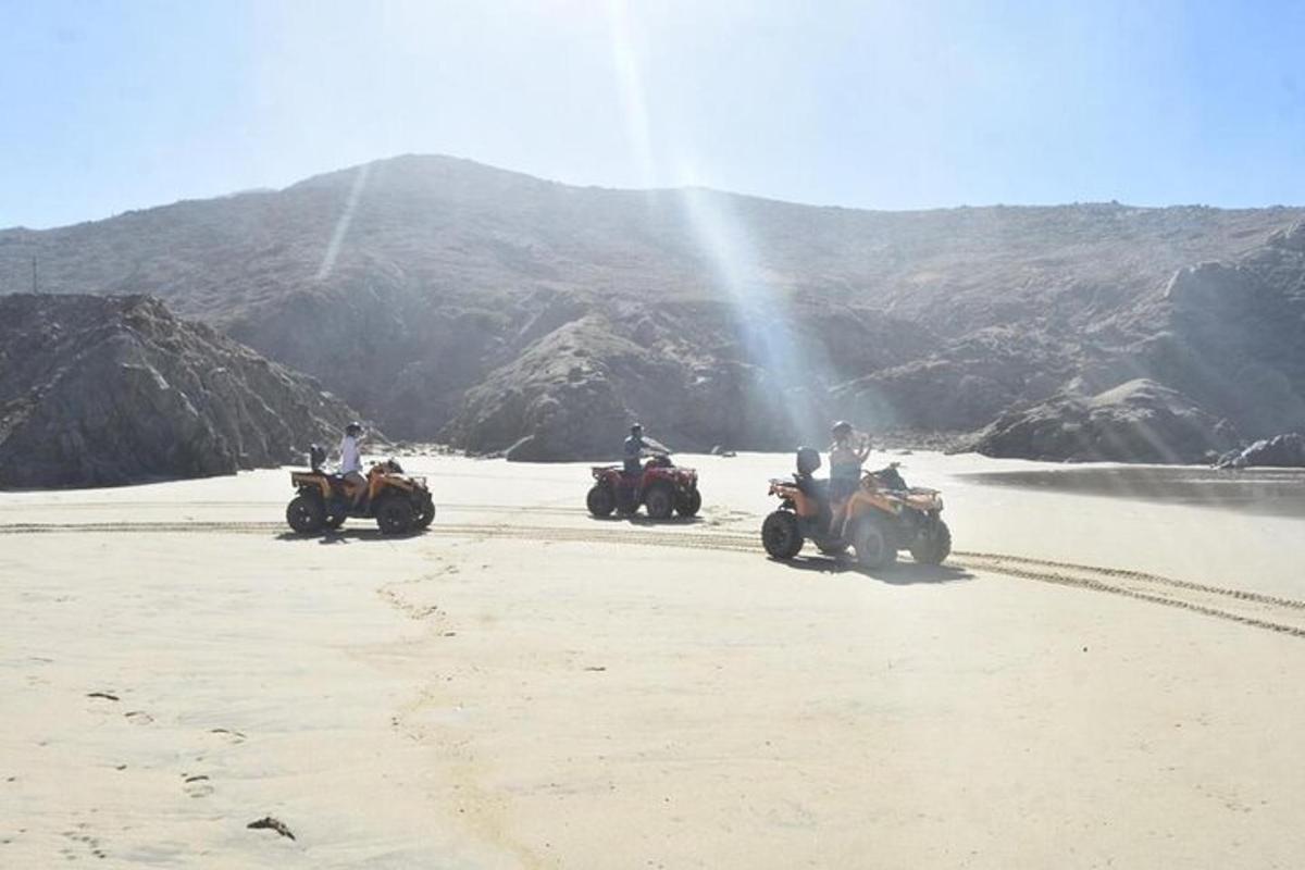 en gruppe mennesker som kjører ATV på stranden