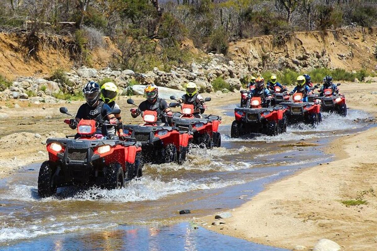 un grup de persones en quads creuant un riu