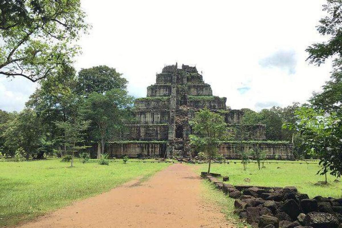 un grande edificio in un campo con una strada sterrata