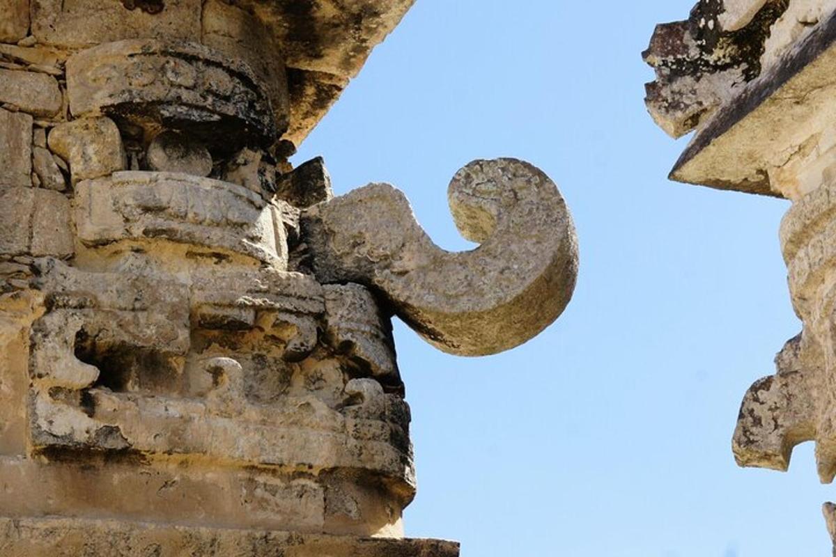 uma velha cruz de pedra na lateral de um prédio
