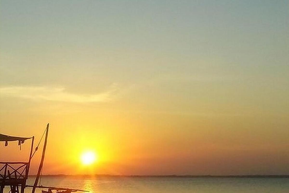 a sunset on the beach with the sun in the sky