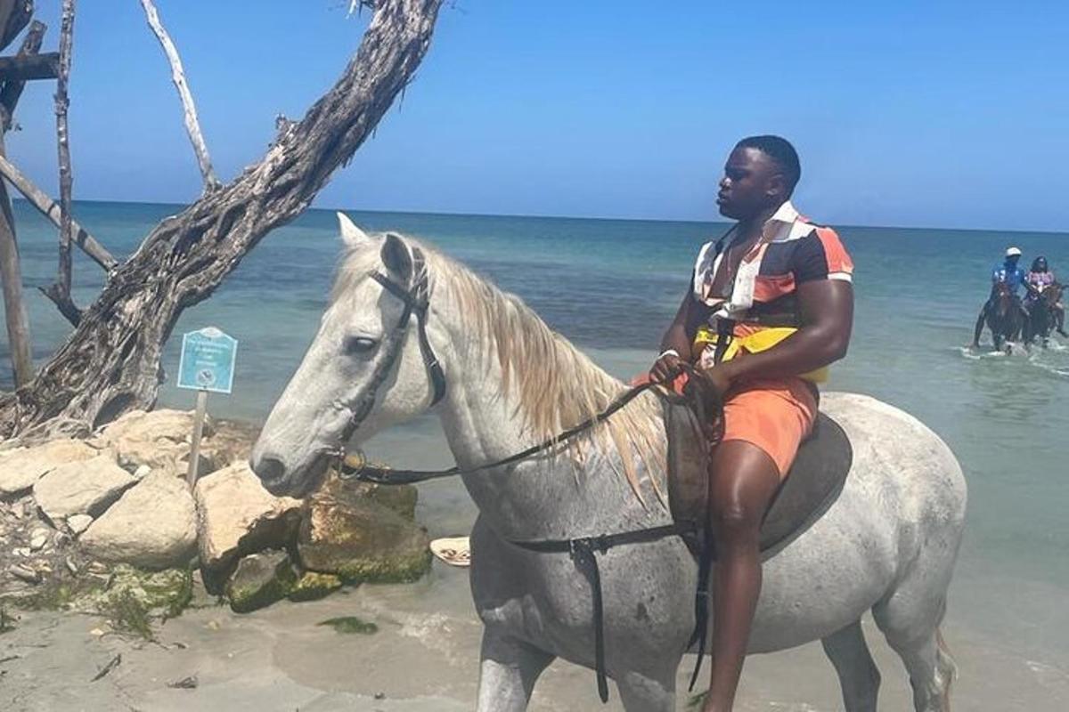un hombre montando a caballo en la playa