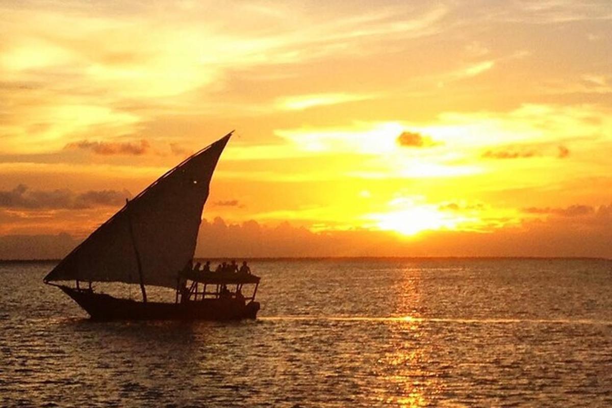 a boat in the ocean with a sunset in the background