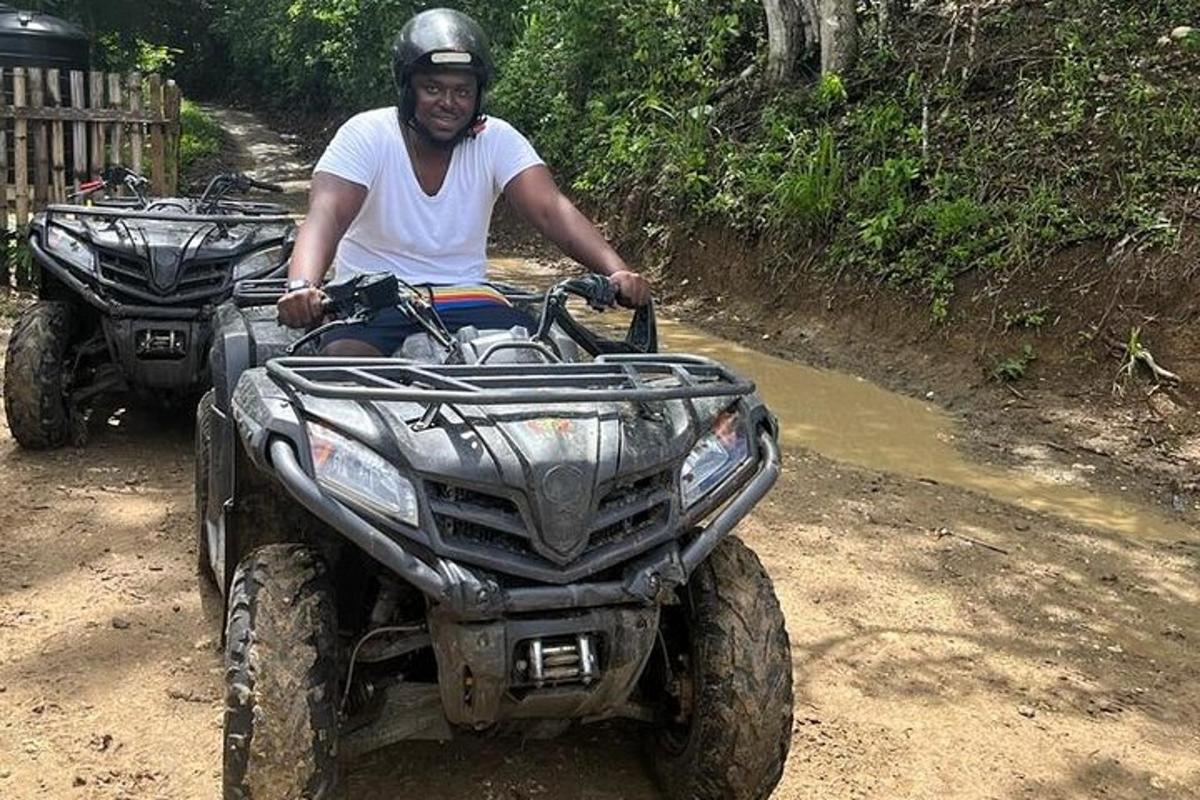 um homem andando de quadriciclo em uma estrada de terra