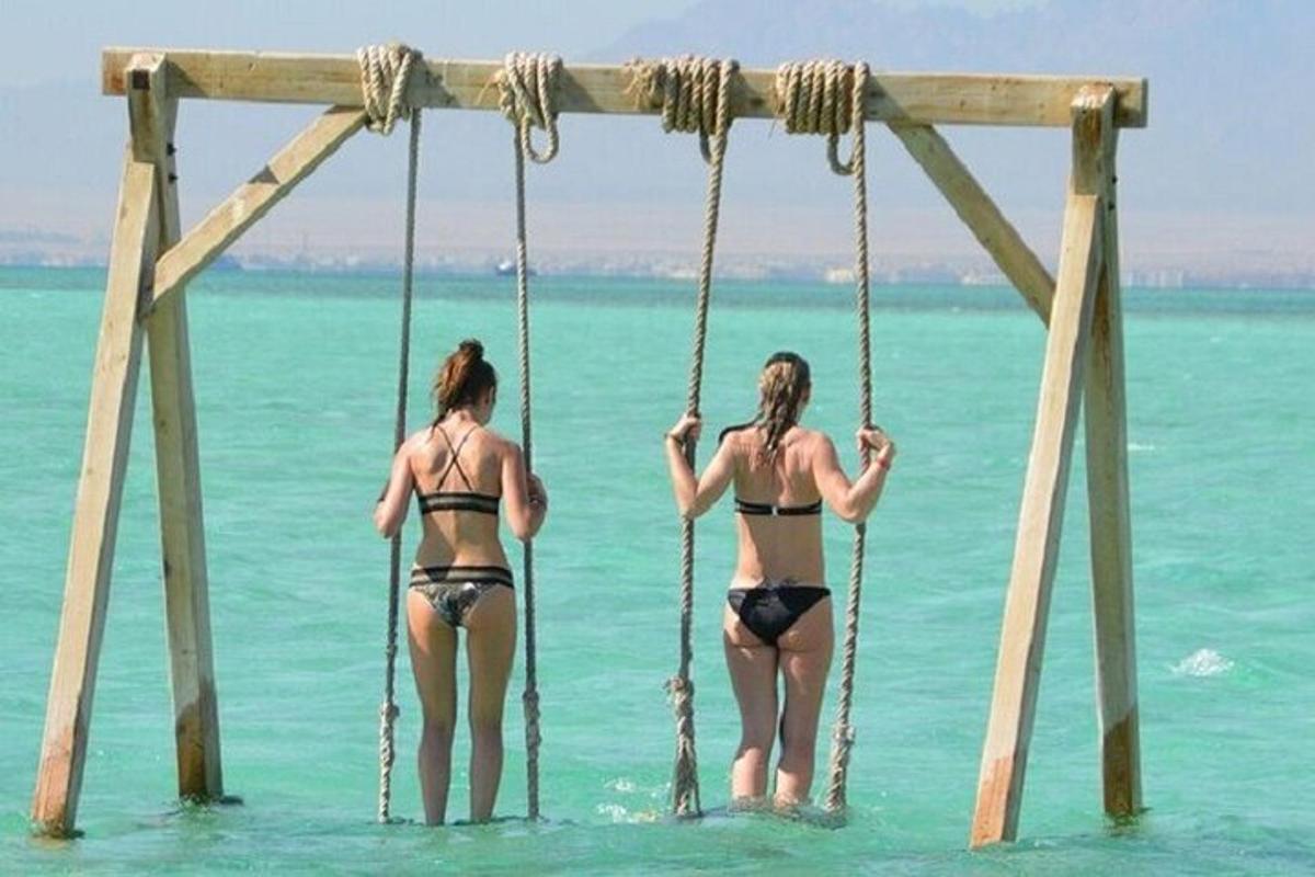 바다의 그네에 수영복을 입은 두 여자
