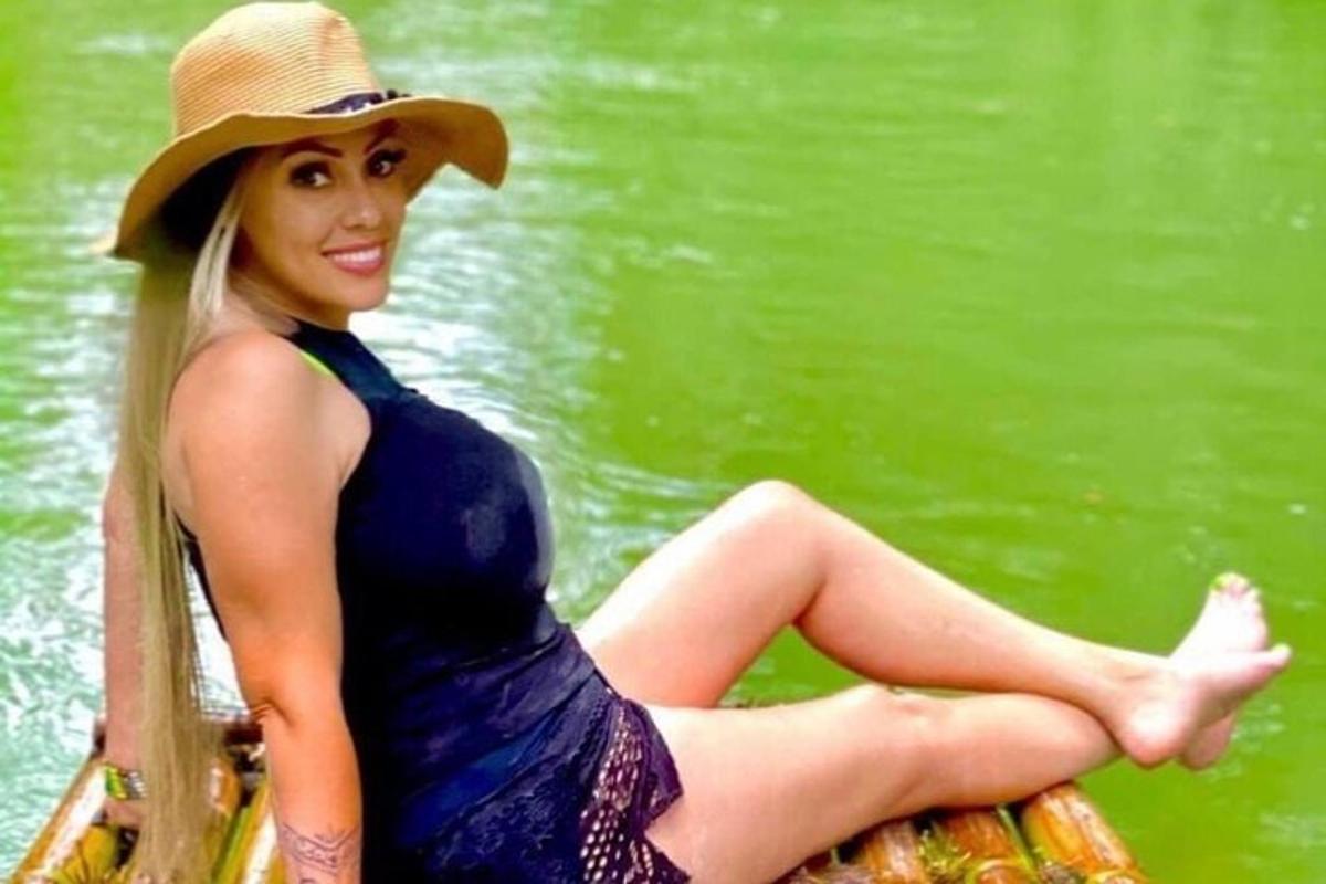uma mulher de vestido azul e chapéu sentada em um barco