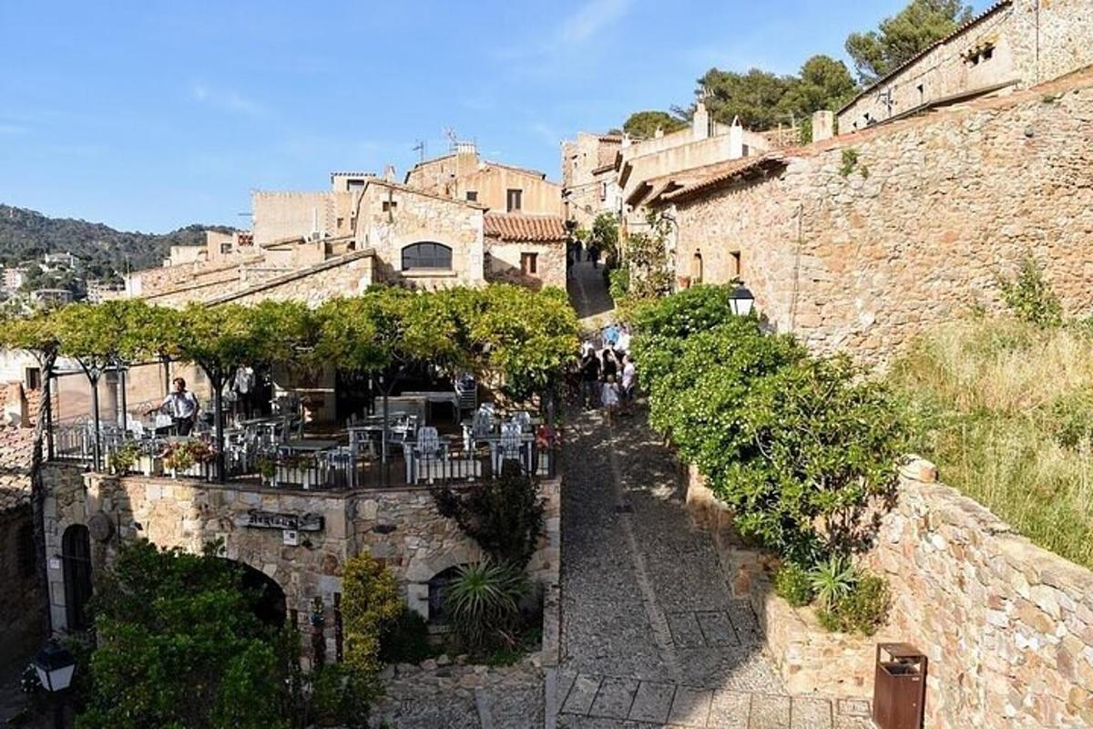Un callejón con mesas y sillas frente a un edificio.