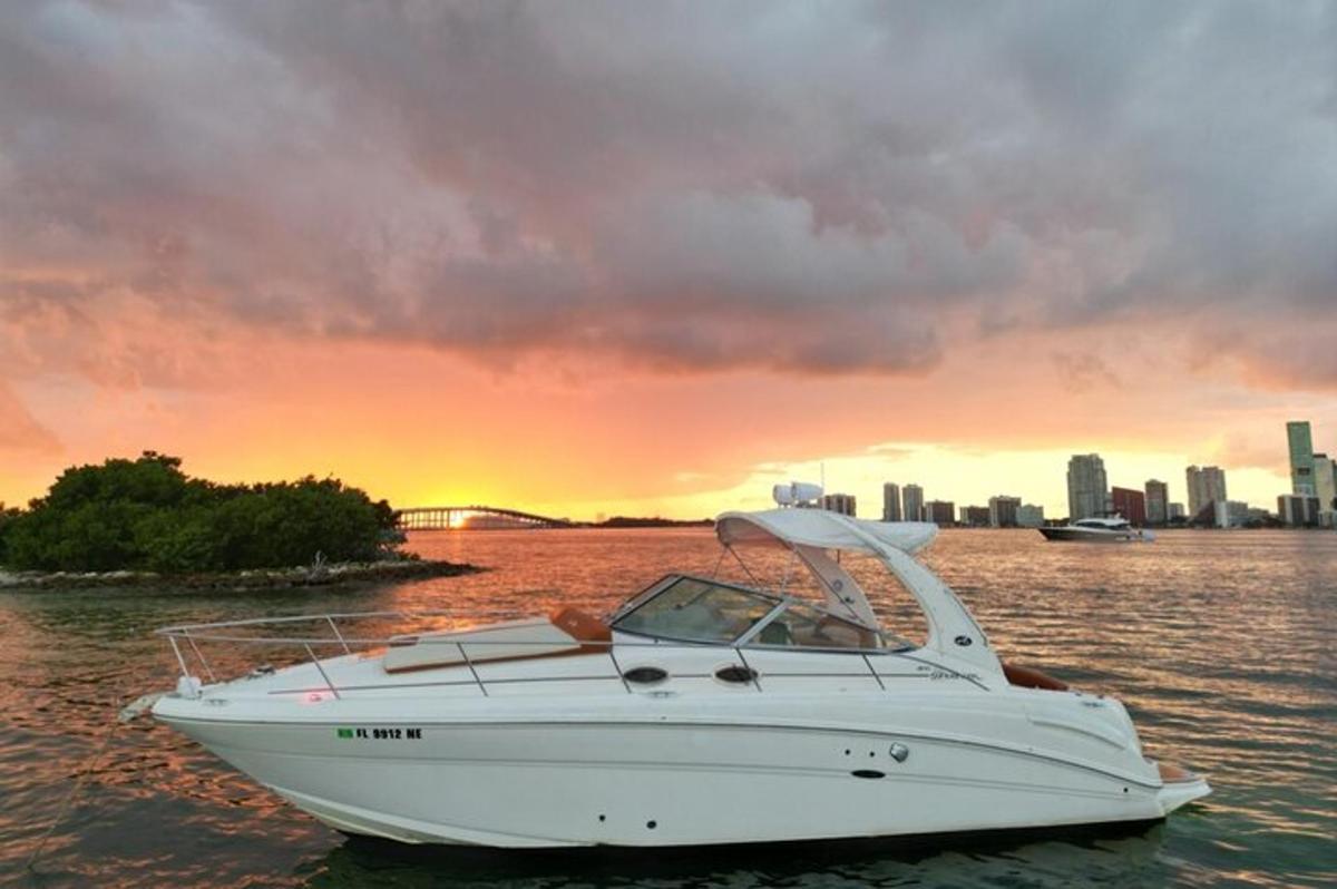 a white boat in the water with a city in the background