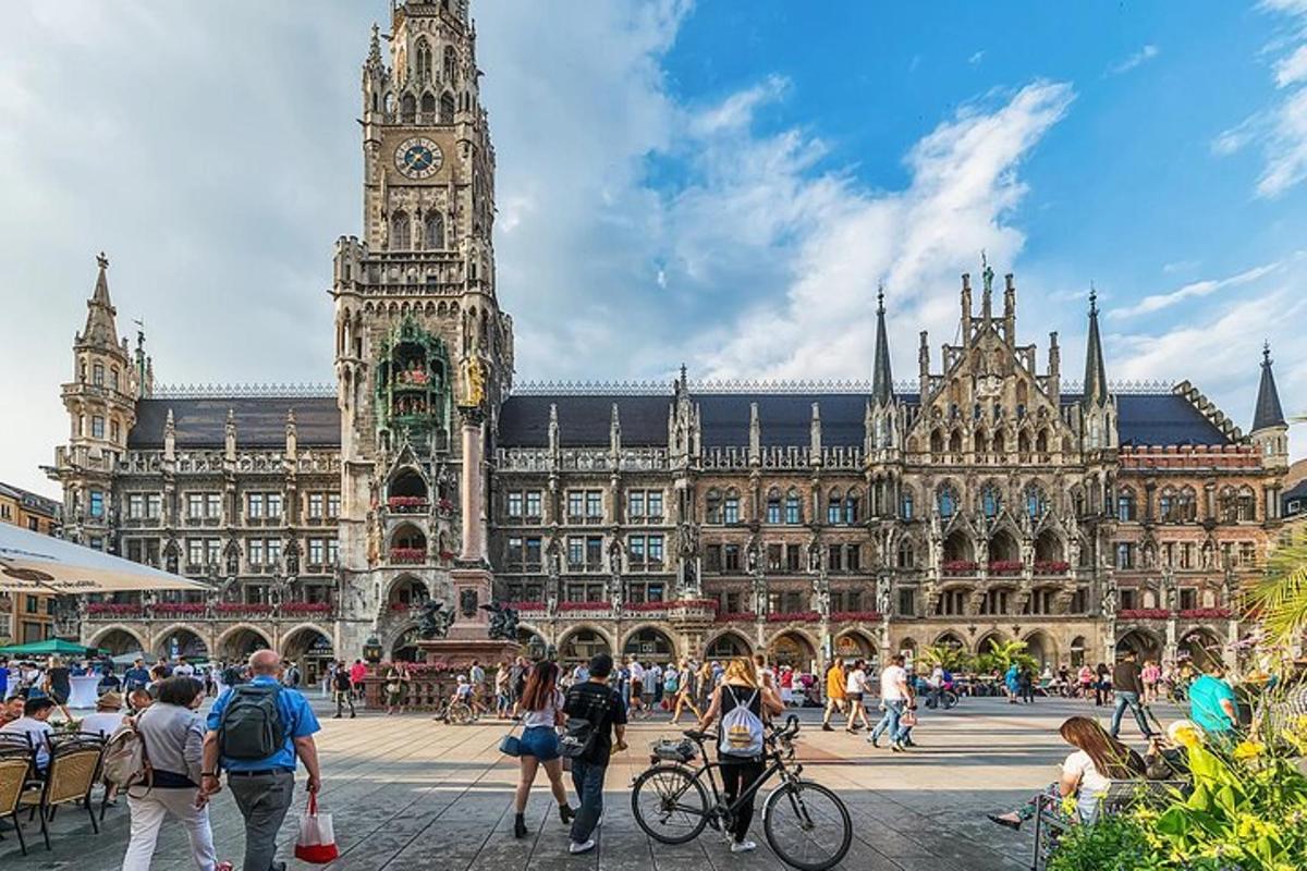 veľká budova s hodinovou vežou a ľuďmi, ktorí sa okolo nej prechádzajú