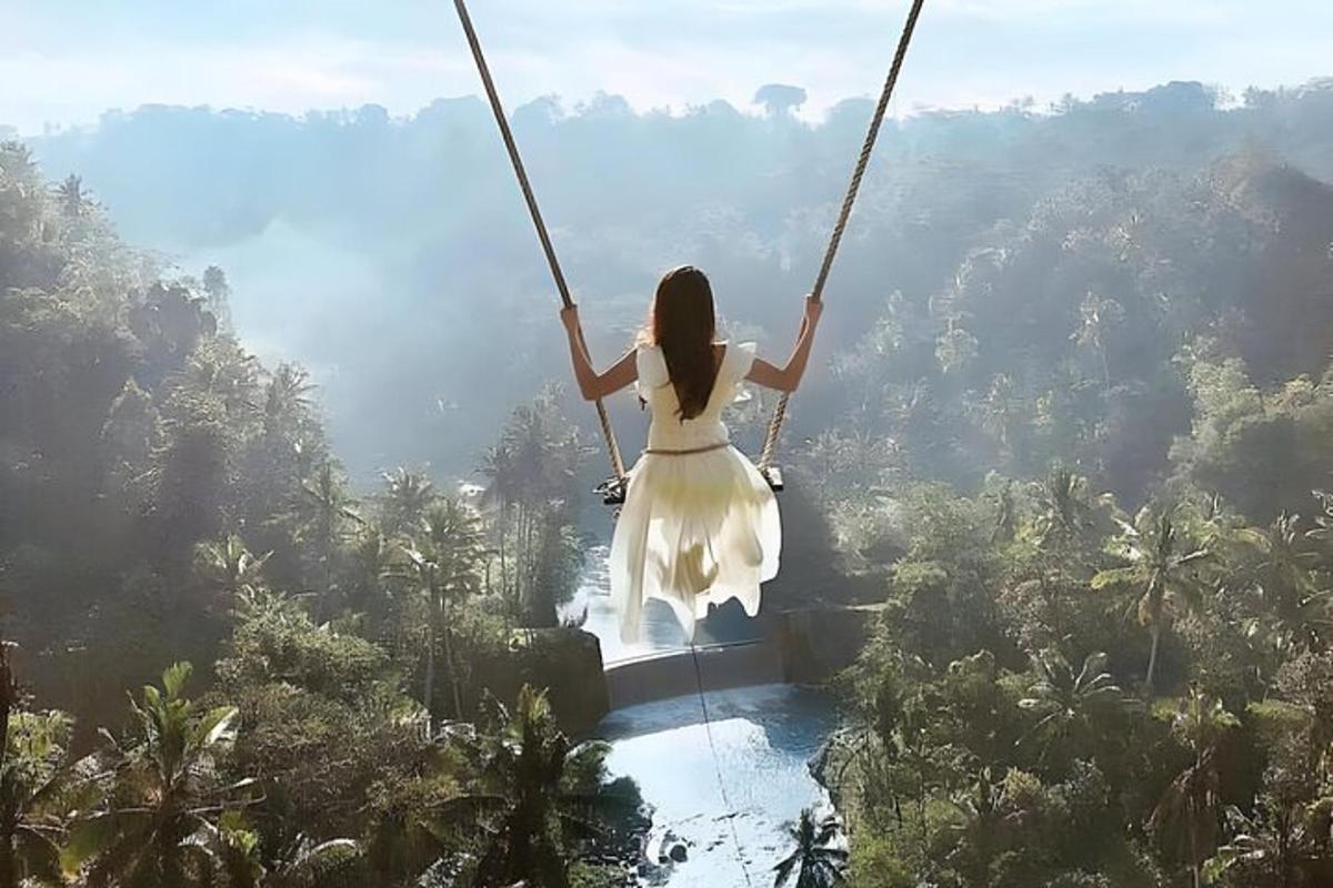 a woman swinging on a swing in the jungle