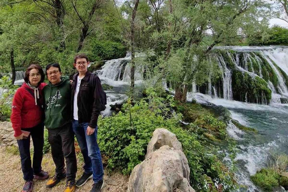 a group of people standing in front of a waterfall