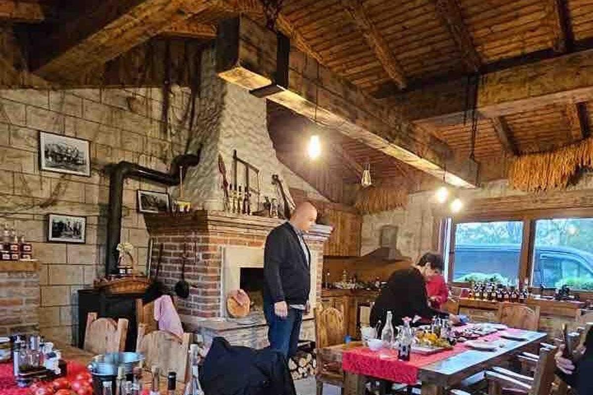 a man standing in a restaurant with people sitting at tables