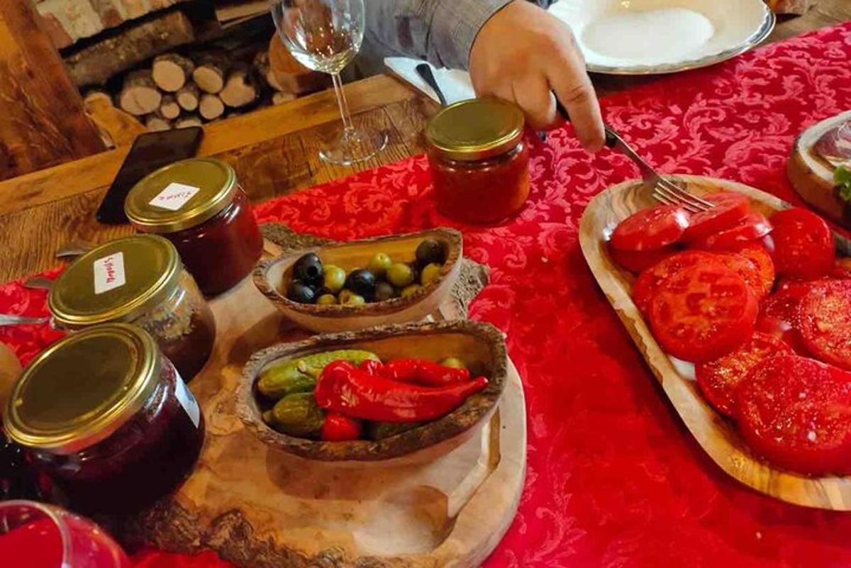 a person holding a spoon over a table with food