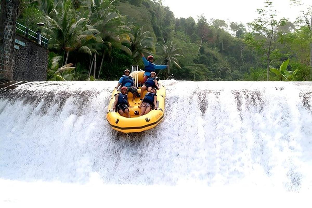 sekelompok orang di atas rakit di air terjun