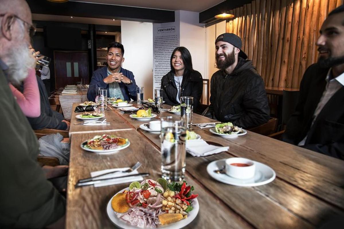 grupp inimesi, kes istuvad laua ümber ja söövad toitu
