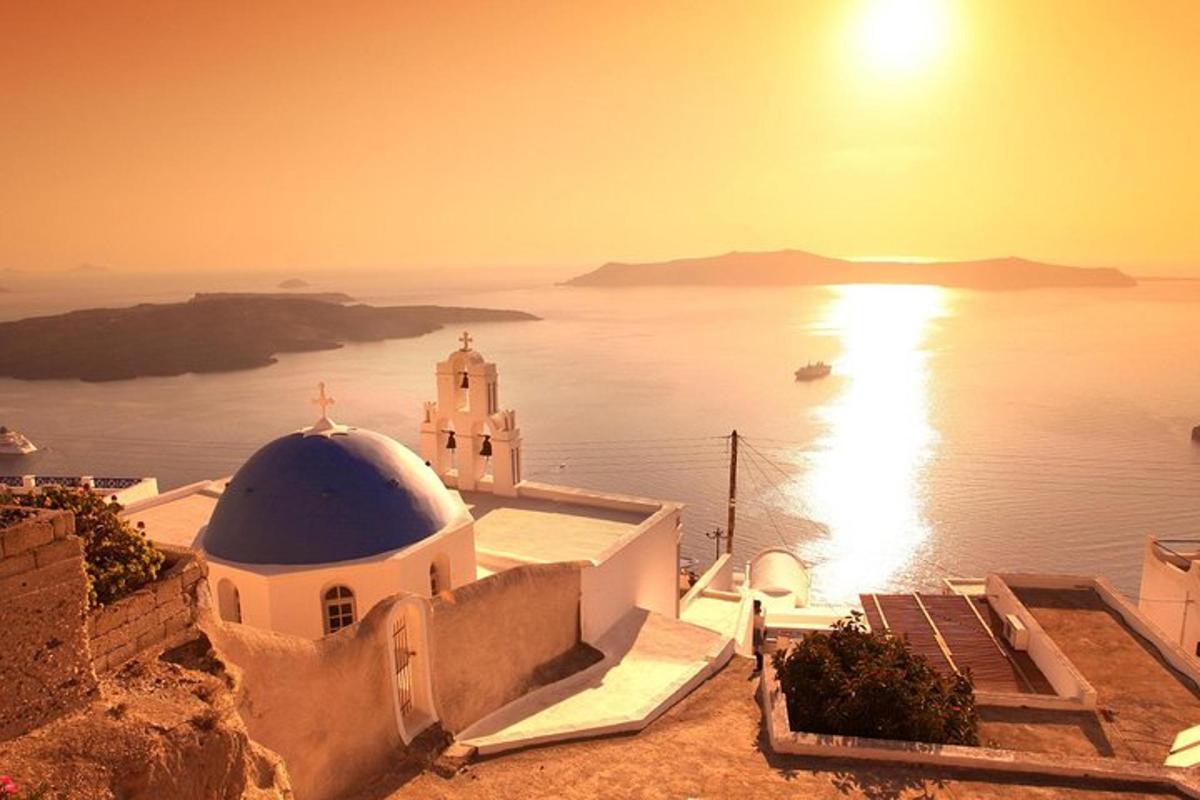 una vista di una chiesa e dell'oceano al tramonto