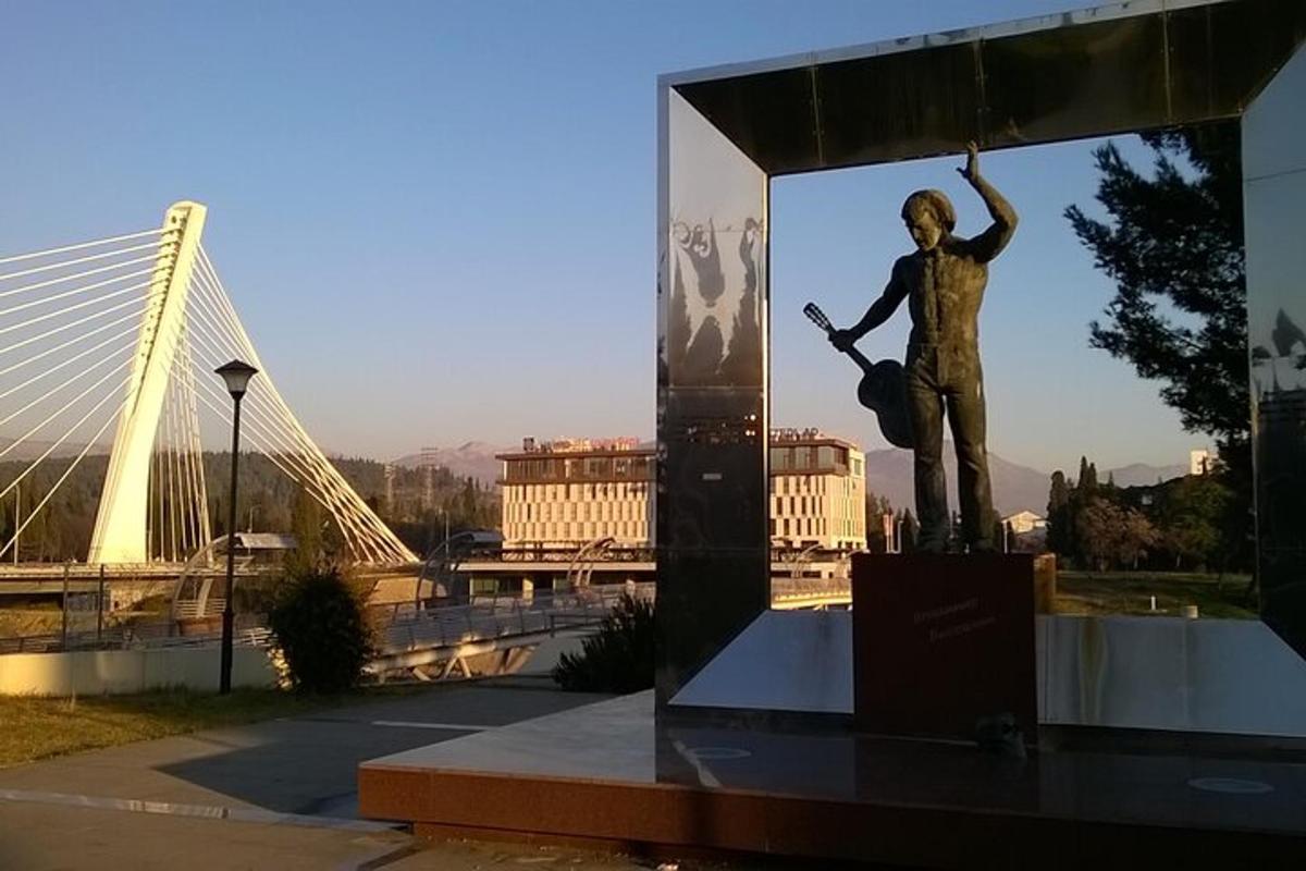 eine Statue eines Mannes, der neben einer Brücke steht