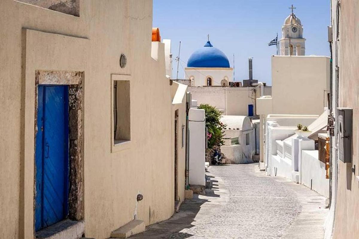 uno stretto vicolo con edifici bianchi e una porta blu