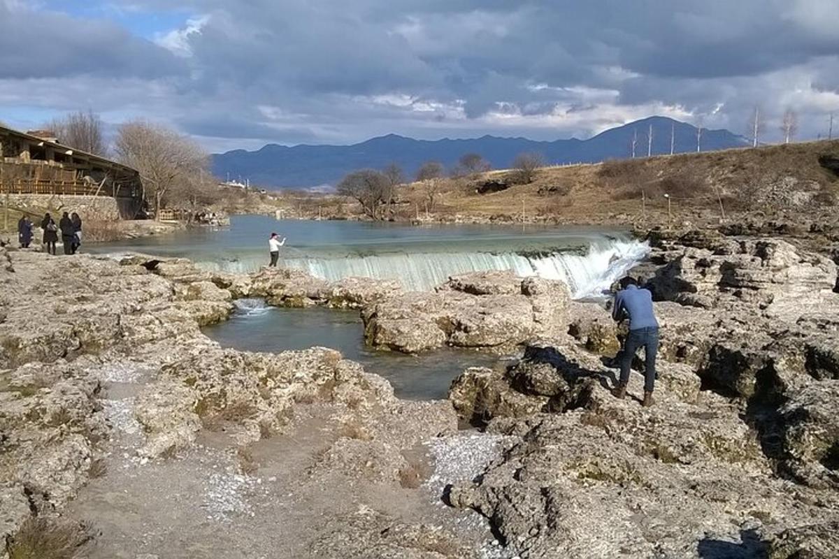 eine Gruppe von Menschen steht vor einem Wasserfall