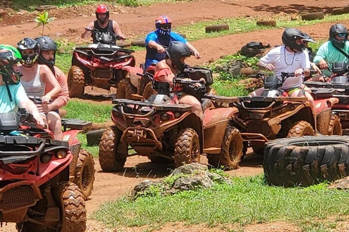 um grupo de pessoas andando de quadriciclo em uma estrada de terra