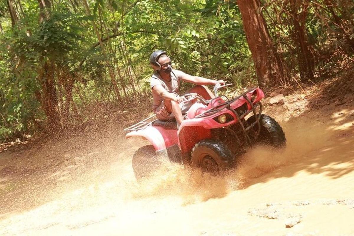 um homem pilotando um quadriciclo vermelho na terra