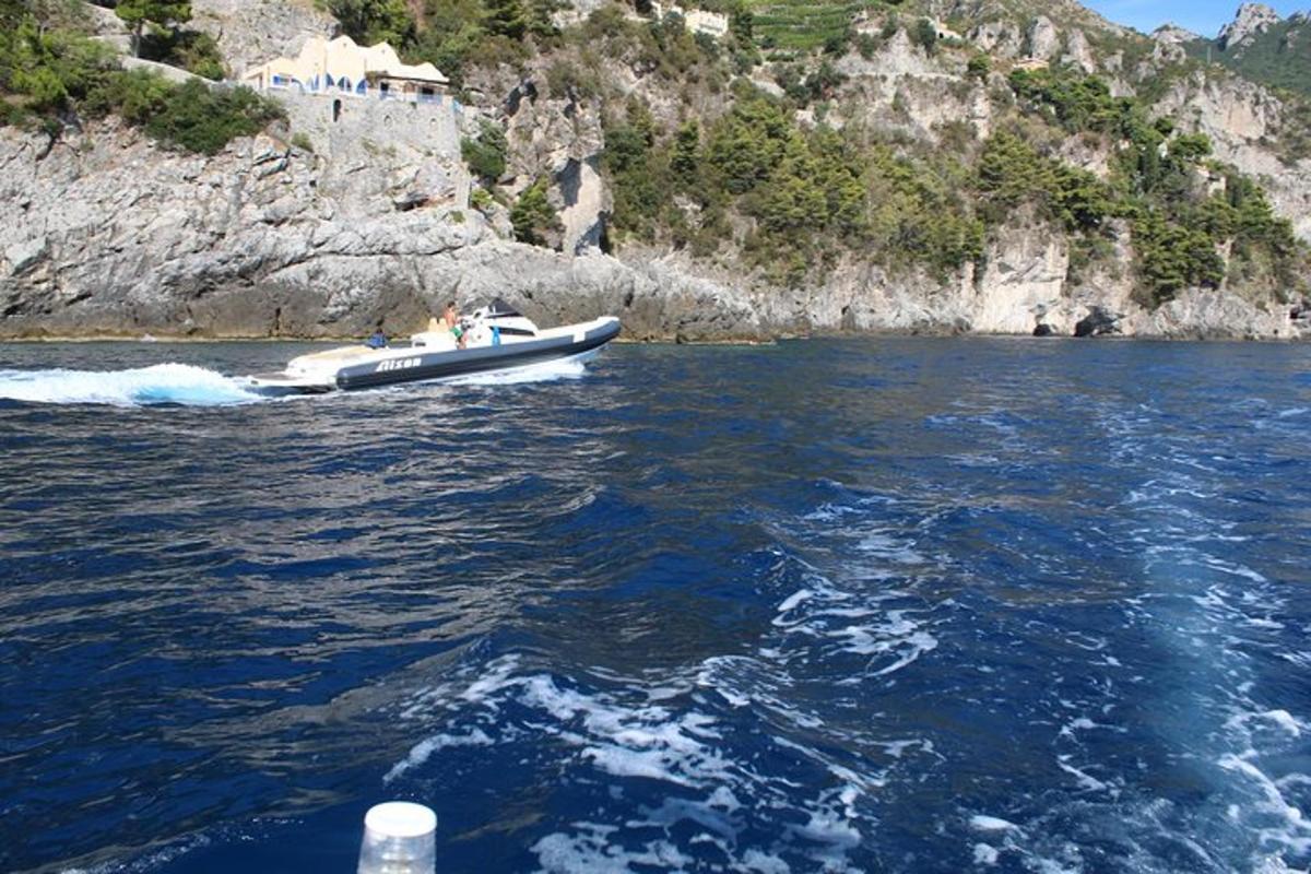 μια βάρκα στο νερό δίπλα σε ένα βουνό