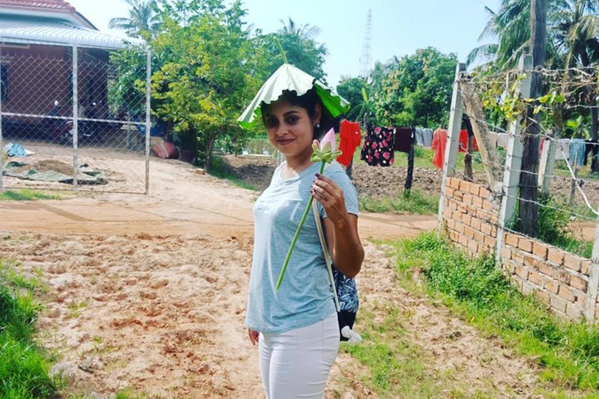 o femeie care ține o umbrelă pe un drum de pământ