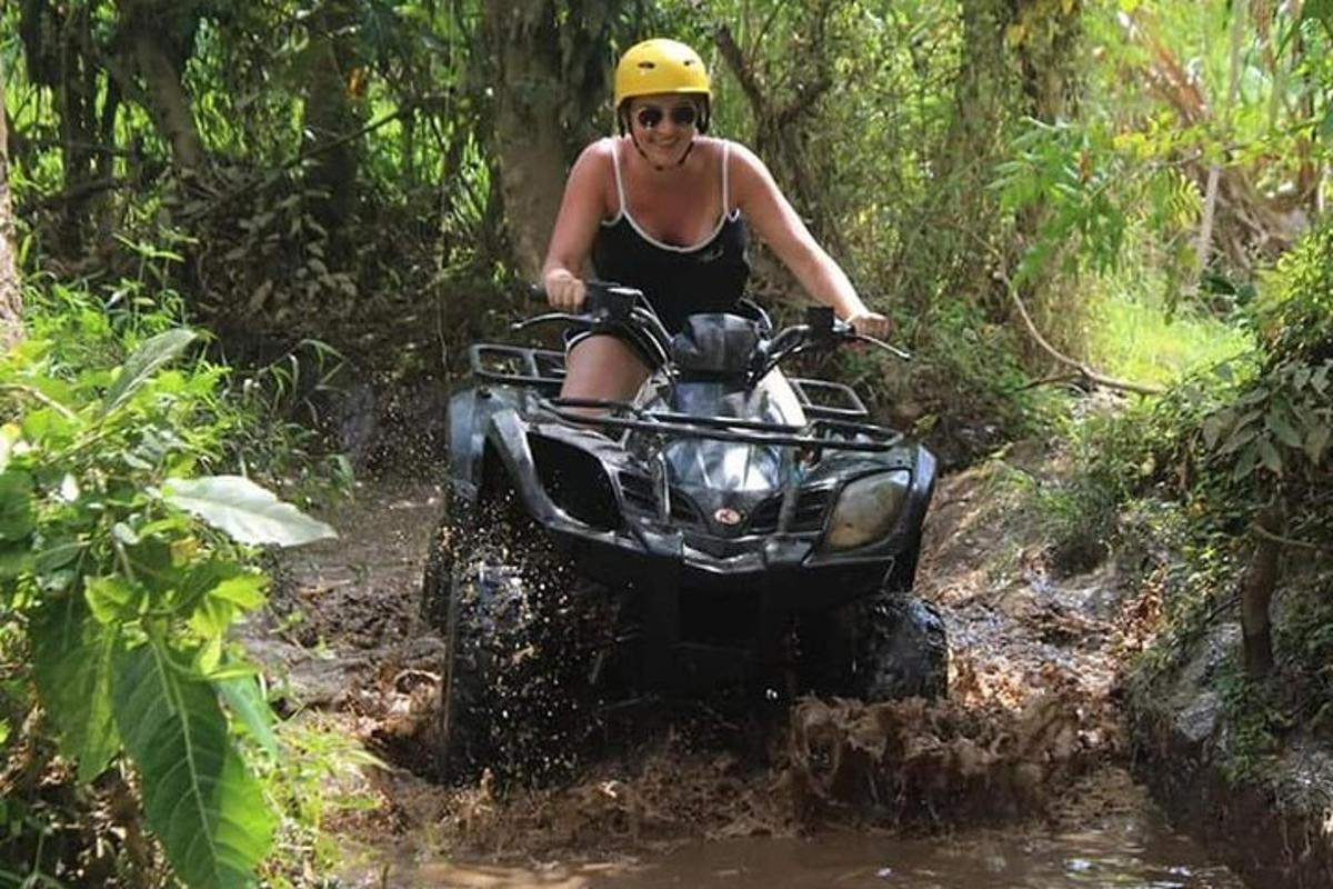 uma mulher andando de quadriciclo na lama