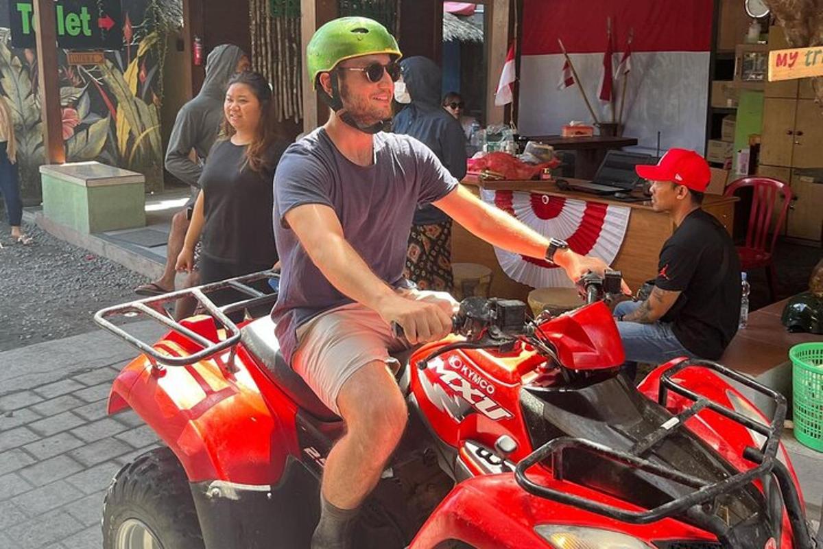 um homem está sentado em um quadriciclo vermelho