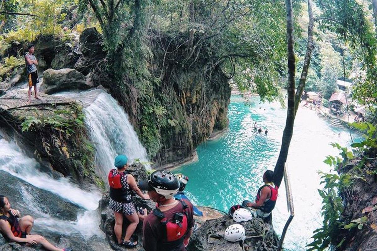 Un grupo de personas de pie al borde de una cascada.