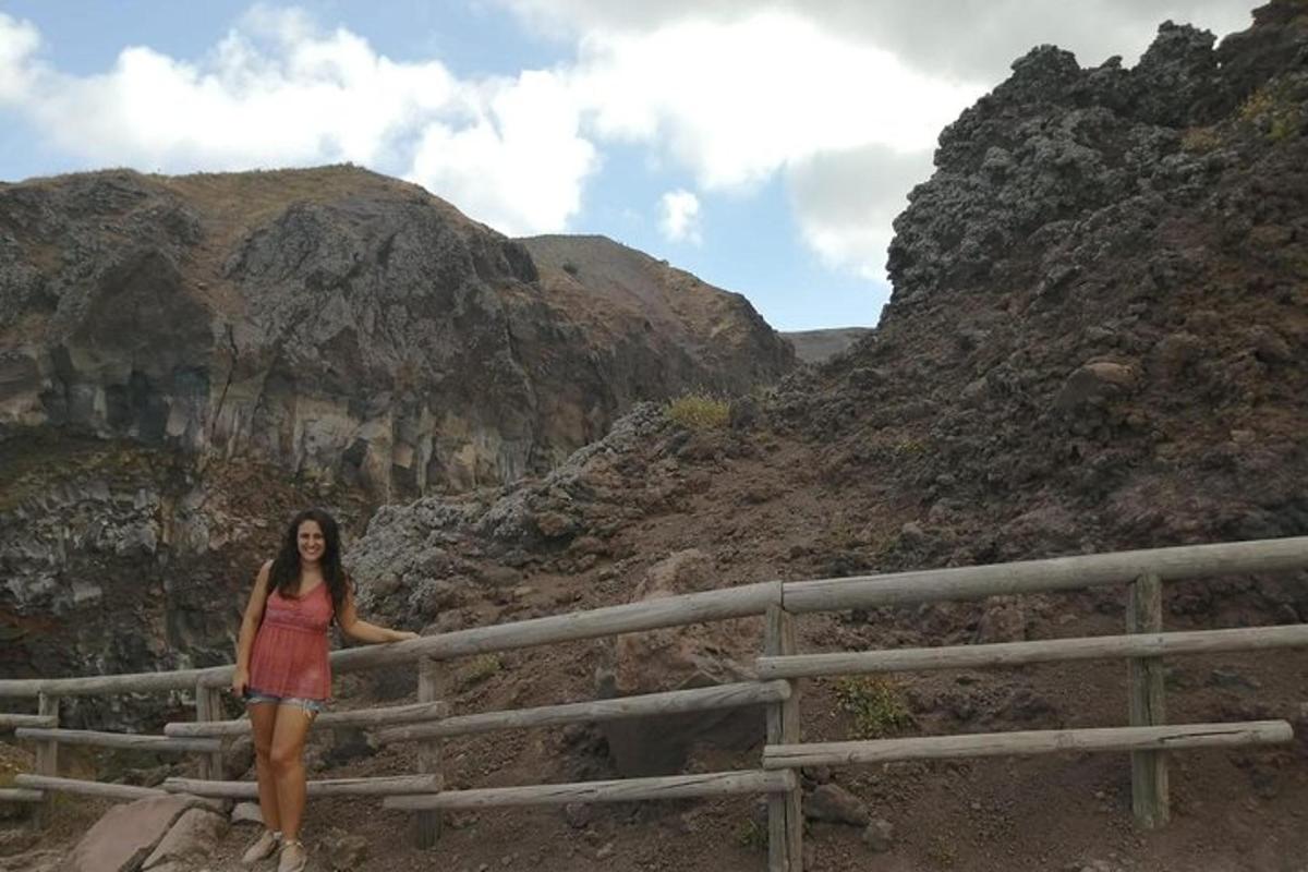 a woman standing on a fence in a canyon