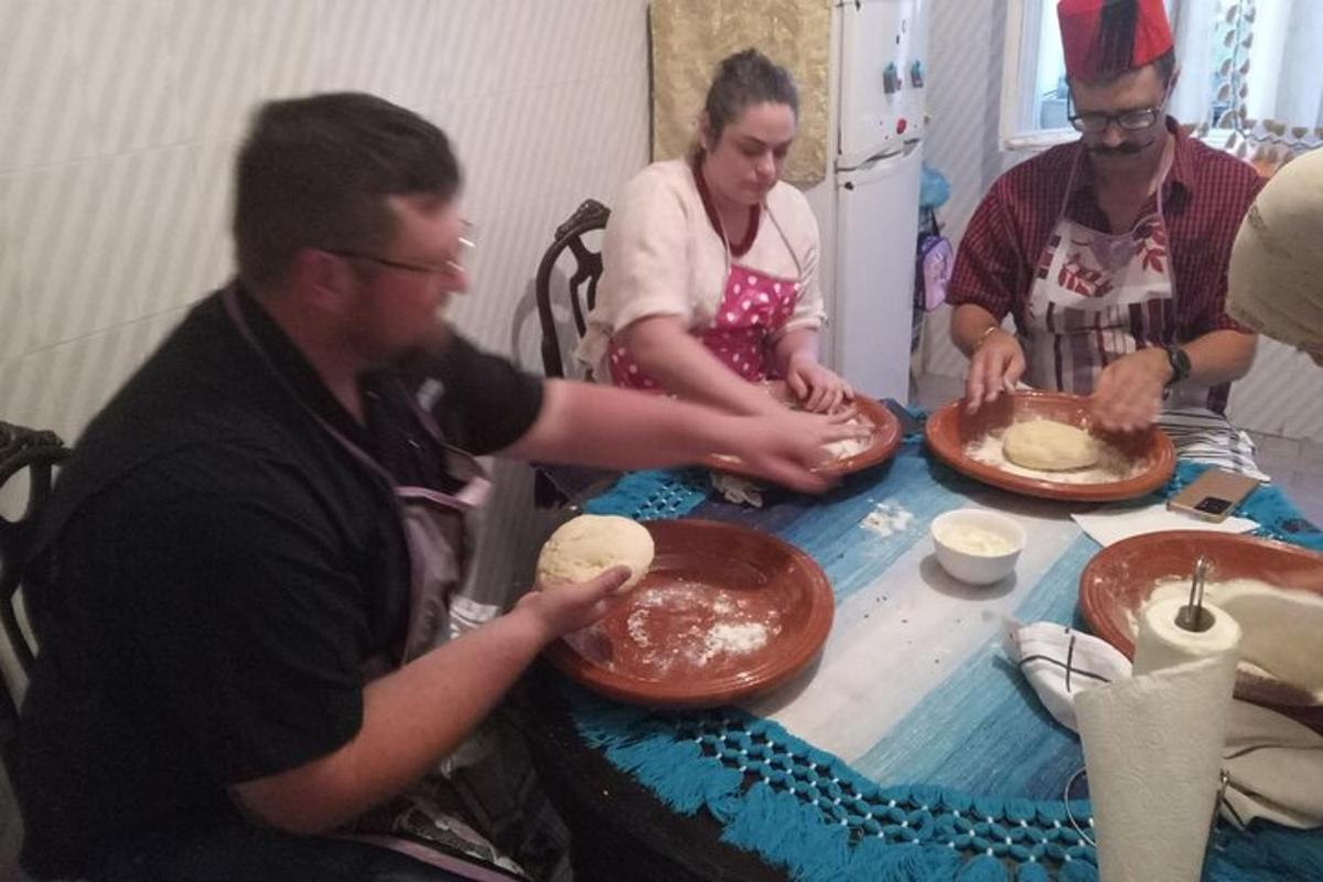 skupina lidí sedících kolem stolu a pečoucích dorty