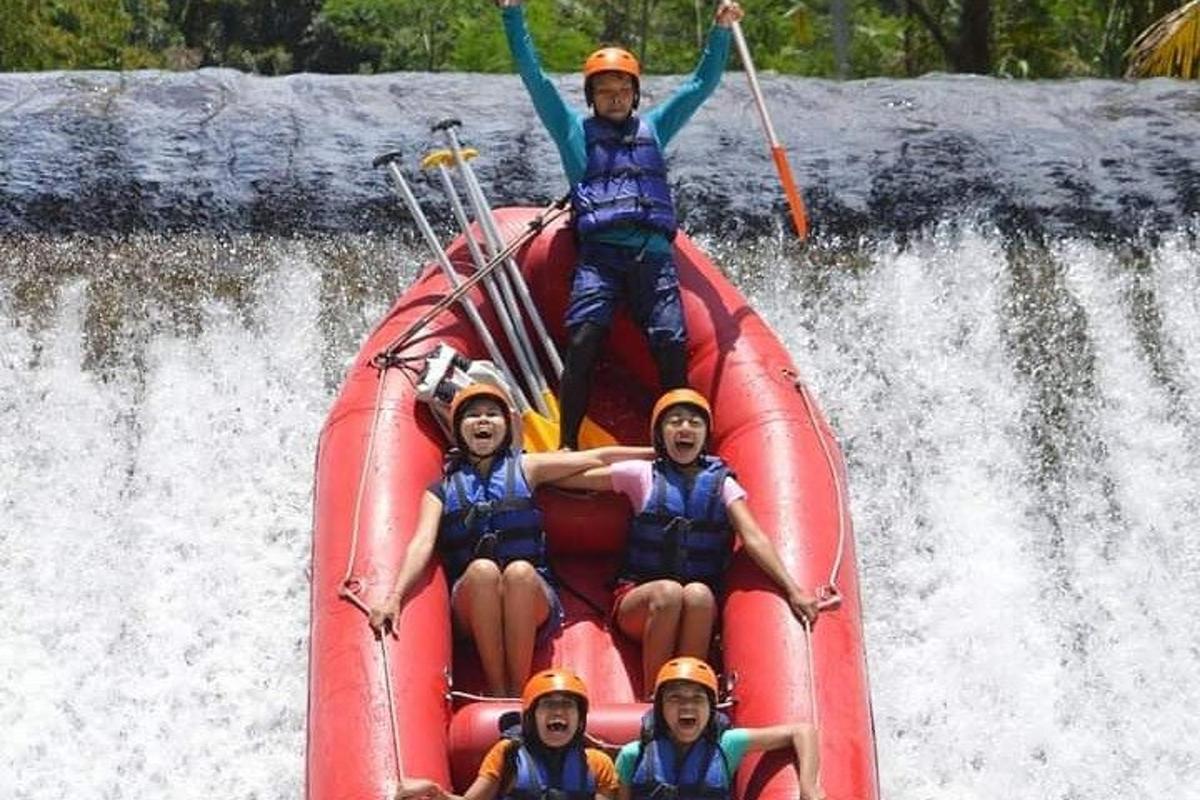 sekumpulan orang di atas rakit di air terjun