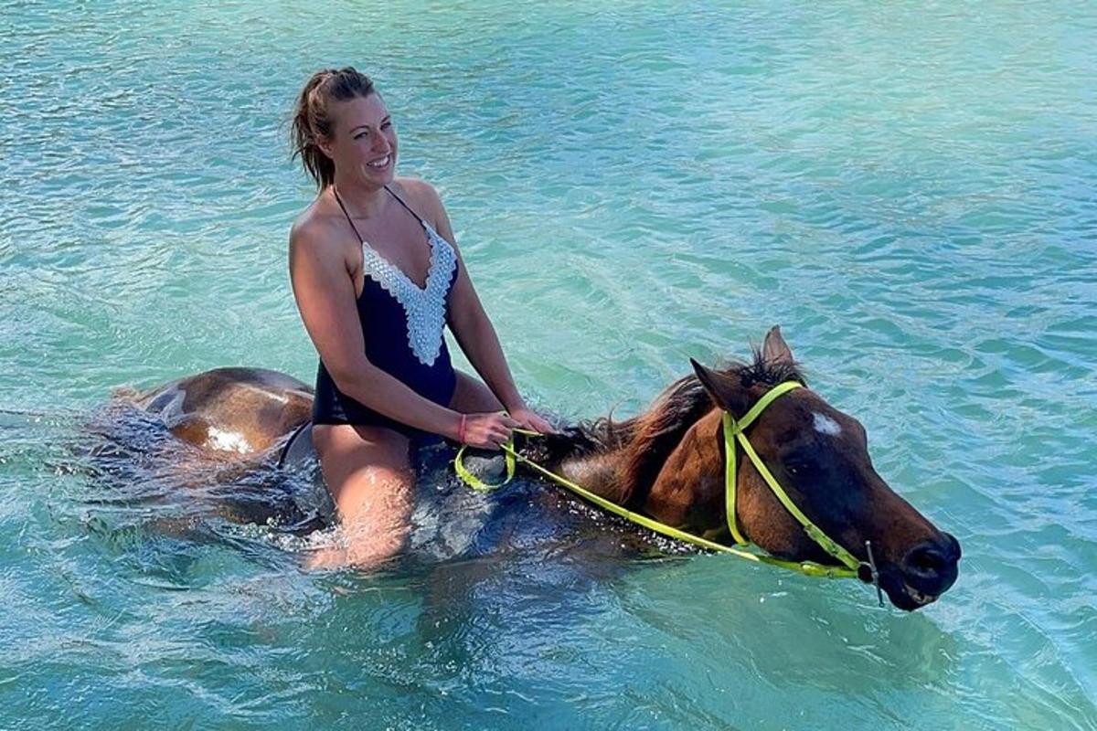 žena jedoucí na koni ve vodě