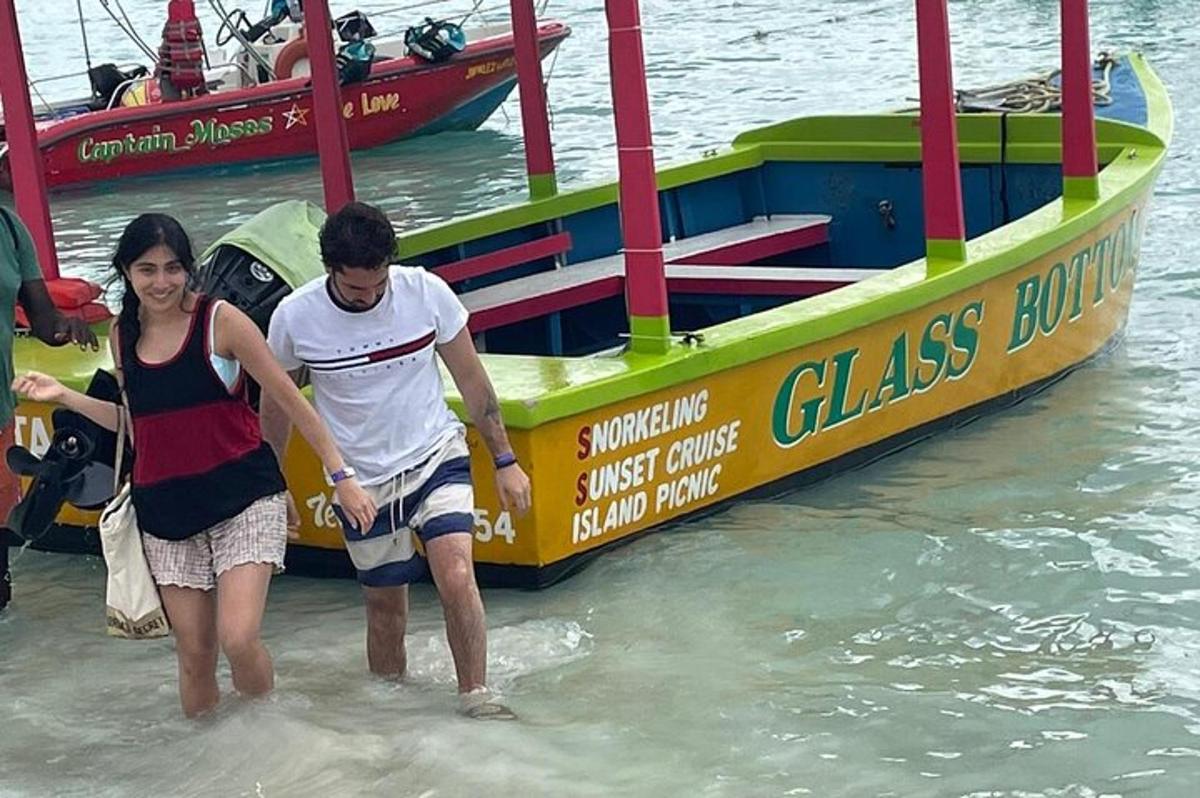a man and a woman standing in the water next to a boat