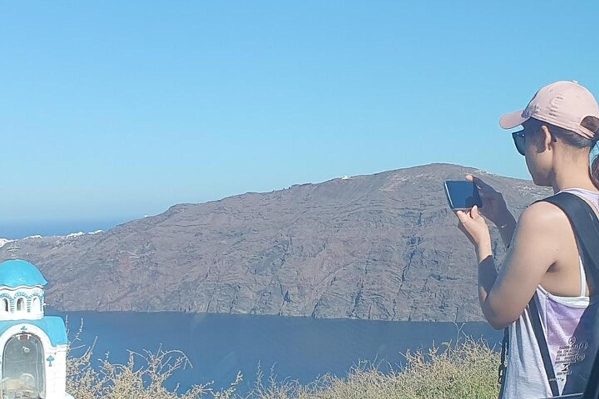 un home fent una foto de l'aigua i d'un far
